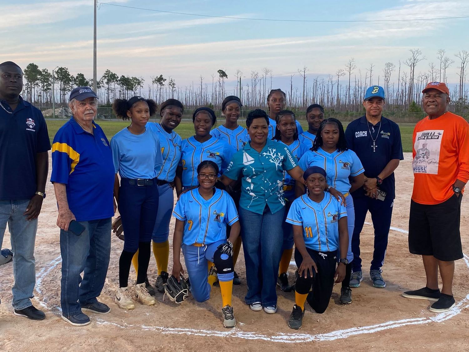 Sagoma-sponsored girls’ softball team photographed on the diamond in Freeport, Grand Bahama, with their coaches